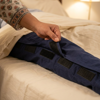 Velcro side panel pressed shut on bedridden care recovery pants, caregiver hand closing full-length seam [bedridden] | Aasra