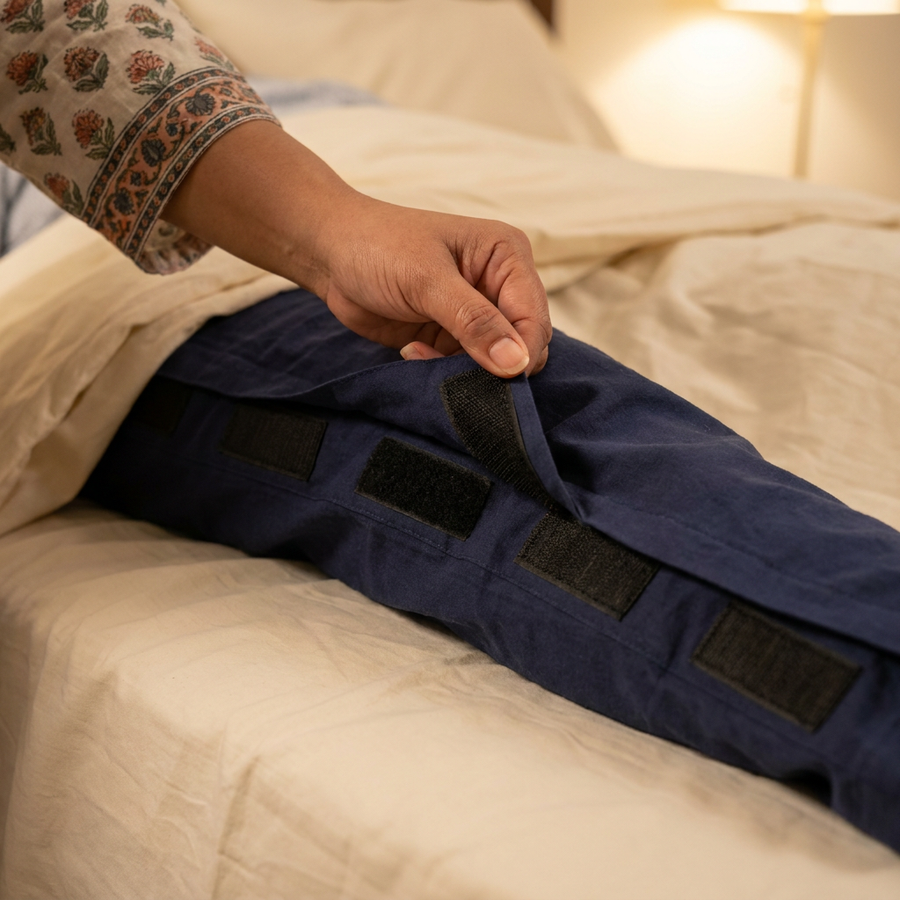 Velcro side panel pressed shut on bedridden care recovery pants, caregiver hand closing full-length seam [bedridden] | Aasra